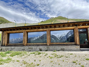 Le vetrate del rifugio riflettono le cime di fronte