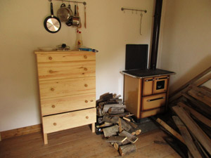 Interno del bivacco: cassettiera e stufa