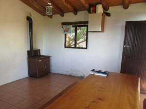 Interno del bivacco (tavolo e stufa)