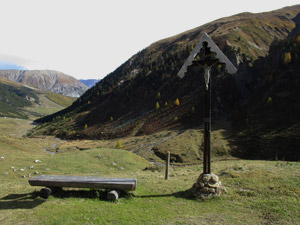 Croce e panca di fronte al bivacco