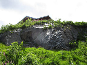 Sopra una roccia spunta il tetto del rifugio