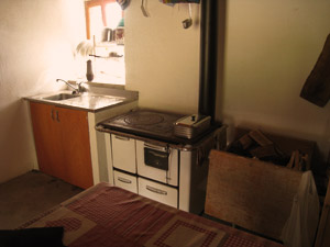 Interno del bivacco: lavandino, stufa, legna