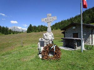 Croce, cippo, rifugio e sullo sfondo la Presolana