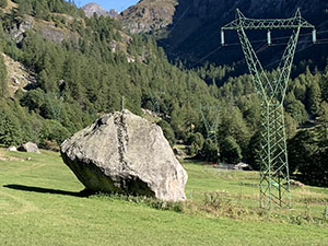 Masso con in cima una croce accanto a un traliccio