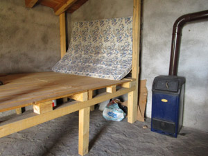 Interno del bivacco: letto e stufa