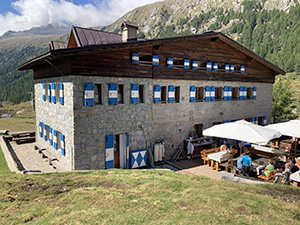 Il retro del Rifugio Val di Fumo con tavoli all'aperto